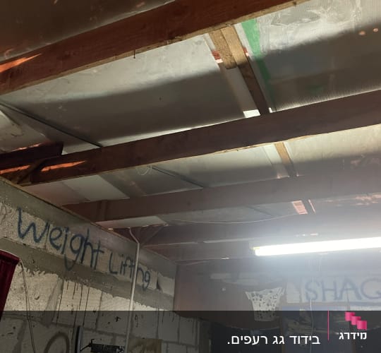 תקרת עץ עם קורות חשופות ותאורה פלורסנטית